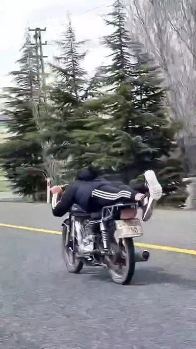 Canını hiçe saydı, motosikletin üzerine uzanarak seyretti
